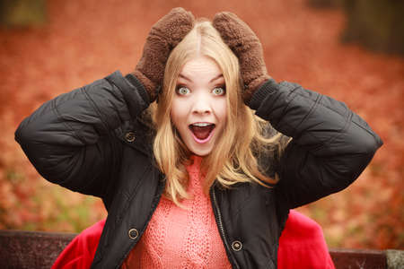 Winter autumn fashion. Blonde young woman in warm clothing brown gloves outdoor