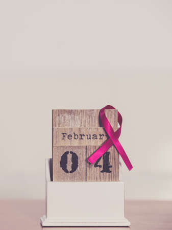 Old fashioned calendar with 4 february world breast cancer day, date with pink awareness ribbon....