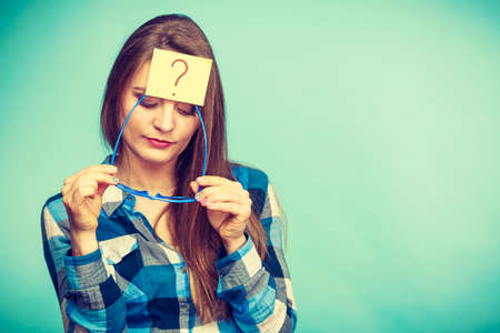 Thinking woman with big nerdy eyeglasses and question mark on forehead. Creating new idea, studying and education concept.の写真素材