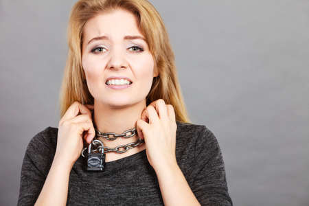 Slavery, medical concept. Unhappy woman having chain around neck, sore throat problem.の写真素材