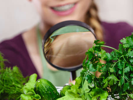 Buying healthy dieting food concept. Woman in kitchen having many green vegetables looking through...