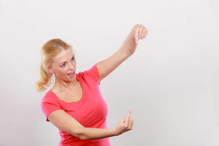Gestures, pointer concept. Happy woman pointing with two fingers on right side next to her. Studio shot on light grey backgroundのeditorial素材
