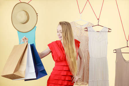 Woman in shop picking summer clothes, making perfect outfit, choosing clothing from new collection, holding many paper bags. Fashion, good shopping concept.のeditorial素材
