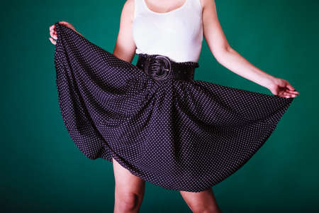Fashion, clothing concept. Woman wearing retro black and white dress with big belt. Studio shot on...