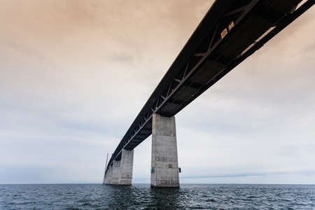 Oresundsbron. The Oresund bridge link between Denmark and Sweden, Europe, Baltic Sea. View from sailboat. Overcast sky. Landmark and travel.の写真素材