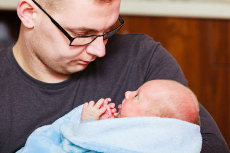Family, fatherhood concept. Daddy holding his little newborn baby in blanket.