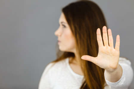 Angry apodicticity woman showing stop sign gesture with open hand, denying something,
