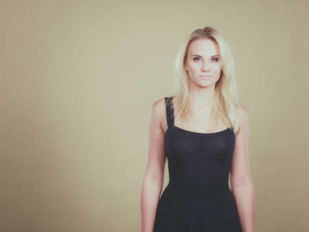 Summer trendy fashionable outfit ideas concept. Blonde attractive woman wearing short blue cocktail dress.の写真素材