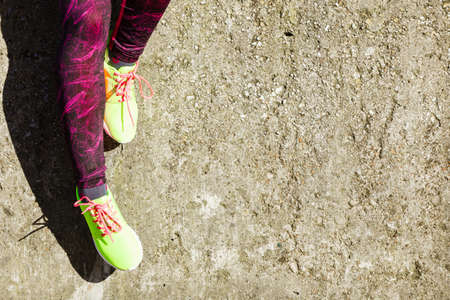 Sports and activities. Part body of training active sporty girl outside. Slim fit legs in vivid...