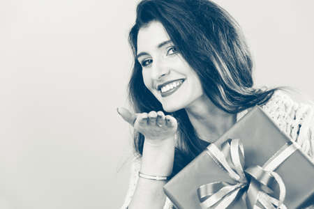 Cheerful woman holding present big gift box. Christmas season celebration concept.の写真素材