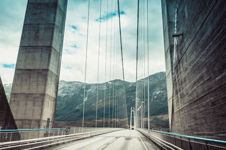Suspension bridge in Norway. View from car. Norwegian infrastructure.のeditorial素材