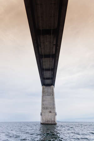 Oresundsbron. The Oresund bridge link between Denmark and Sweden, Europe, Baltic Sea. View from sailboat. Overcast sky. Landmark and travel.のeditorial素材