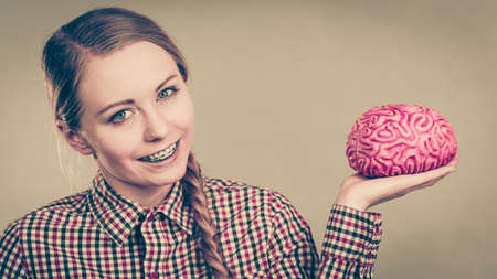 Intellectual expressions, being focused concept. Closeup of attractive woman happy thinking face expression holding brainのeditorial素材