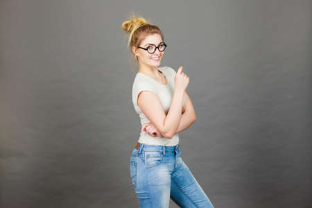 Happy teenage woman wearing eyeglasses, white t shirt and jeans. Teenager fashion concept.のeditorial素材