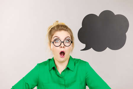 Shocked astonished business woman wearing green shirt with black thinking or speech bubble.の写真素材