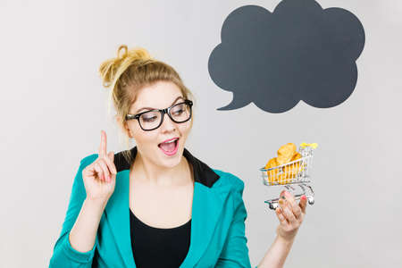 Buying gluten food products concept. Bussines woman holding shopping cart trolley with sweet bun,...