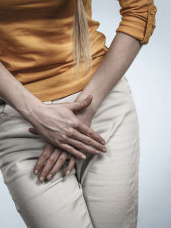 Closeup young sick woman with hands holding pressing her crotch lower abdomen. Medical or...