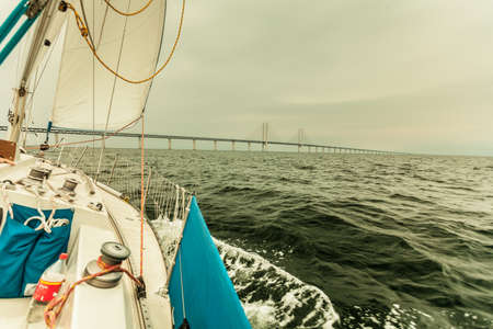 Oresundsbron. The Oresund bridge link between Denmark and Sweden, Europe, Baltic Sea. View from sailboat yacht. Overcast sky. Landmark and travel.の写真素材