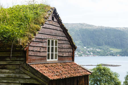 Civilization and nature concept. Norwegian cottage House roof covered with beautiful green mossの写真素材