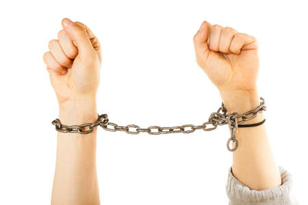 Lack of freedom, social problems concept. Chained man hands with chain around wristsの写真素材