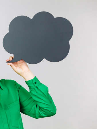 Woman hand pointing at black thinking or speech bubble next to her.