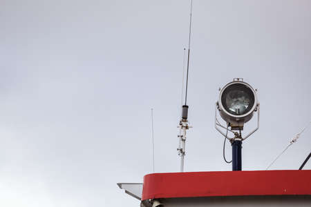 Objects concept. Detailed closeup of lamp on ship, blue sky in background.の写真素材