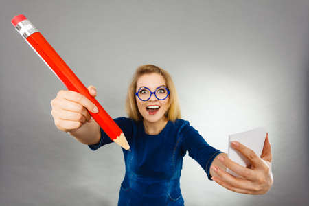 Positive crazy woman blonde student girl or female teacher, business coach holding huge red pencil...