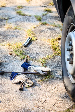 Manual socket wheel wrench and jack lying on ground. Tire car repair objects concept.