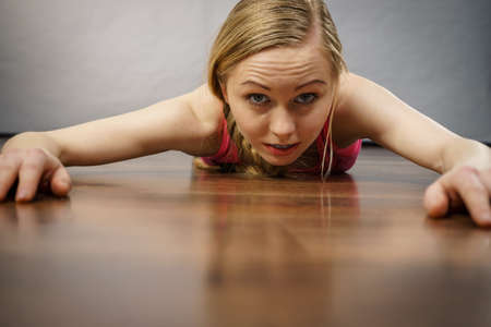 Young woman lying on floor face closeup, she pretending like something is pulling her back.