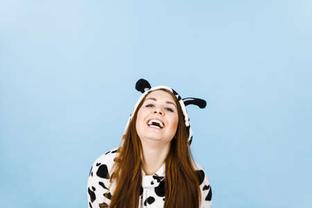Happy teenage girl in funny nightclothes, pajamas cartoon style smiling, positive face expression, studio shot on blue.の写真素材