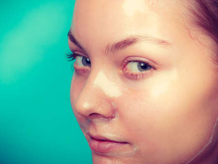 Young woman in facial peel off mask. Peeling. Beauty and skin care. Studio shot on greenの写真素材