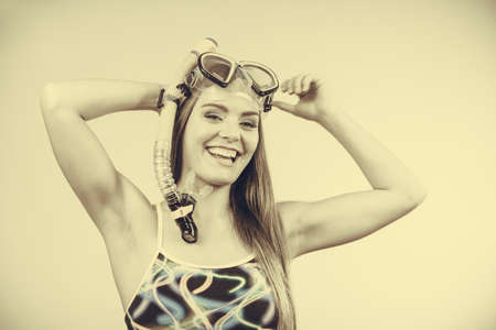Woman wearing swimsuit with snorkeling mask having fun studio shot, Happy joyful girl dreaming about active summer vacation. Snorkeling swimming conceptの写真素材