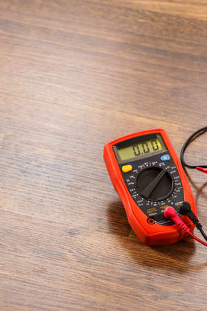 Multimeter measuring device electric tool for measurement of voltage lying on wooden floor backgroundの写真素材