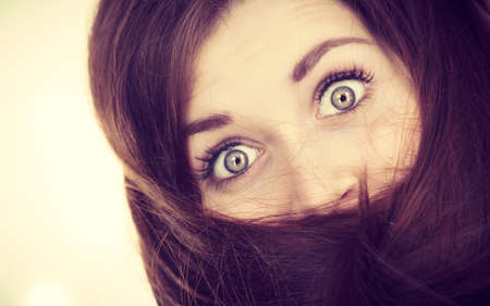 Haircare and hairstyling concept. Woman having face covered with her dark brown hair.の写真素材