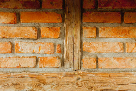 Textures and close up detailed patterns concept. Red brick wall with wooden pieces