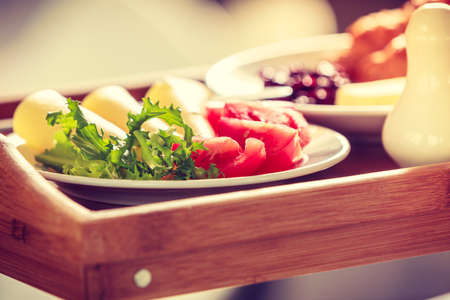 Breakfast consisting of croissants tomatoes, cheese, lettuce and jam. Balanced diet, food, health concept.の写真素材