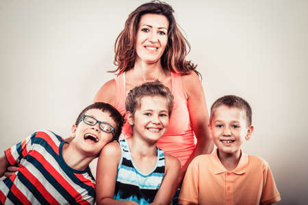 Portrait of happy smiling family sweet cute kids little girl, boys and mother woman in studio. Childhood happiness.の写真素材