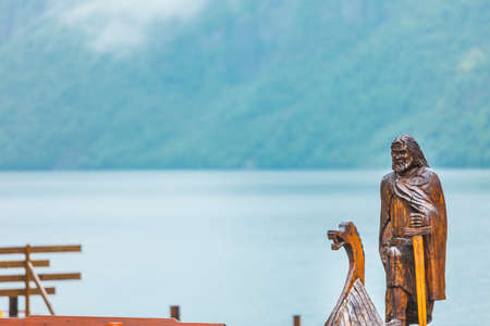 Old wooden viking boat on seashore in norwegian nature, foggy misty day. Mountains and fjord Sognefjord. Tourism and traveling conceptの写真素材