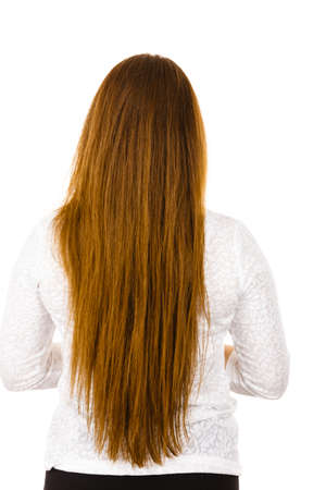 Woman standing backwards showing her long brown healthy hair. Haircare and hairstyling concept.の写真素材
