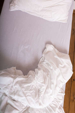 Bedroom, hotel objects, design concept. Bed closeup, white quilt bedding and pillow
