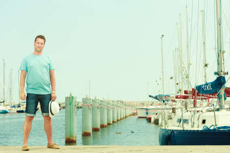 Summertime vacation adventure concept. Man spending his free time walking on marina, sightseeing during summer.の写真素材