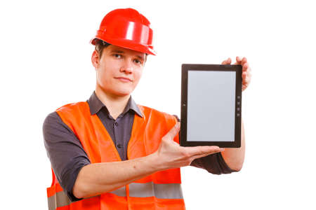 Technological development in company. Young handsome man worker in safety vest and hard hat with tablet. Repairman inspector at work isolated on white.の写真素材