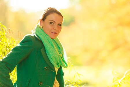 Woman sitting on big tree trunk being close to nature, relaxing in woods or park druing autumn weatherの写真素材
