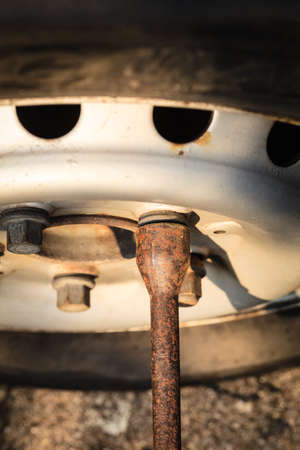 Mechanic fixing, changing and repair old car tire with rim socket wrench