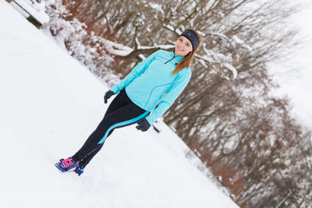 Girl wearing sportswear, trees in background. Winter sports, outdoor fitness, workout, health concept.の写真素材