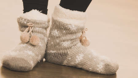 Fashion, clothing, winter time concept. Woman feet wearing woolen warm sock on floor.の写真素材
