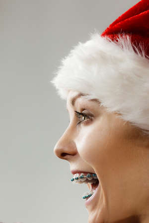 Xmas, seasonal clothing, winter christmas concept. Happy woman wearing windblown Santa Claus helper...