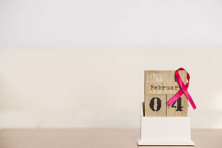 Old fashioned calendar with 4 february world breast cancer day, date with pink awareness ribbon. Healthcare and medicine concept.の写真素材