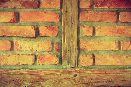 Textures and close up detailed patterns concept. Red brick wall with wooden piecesの写真素材