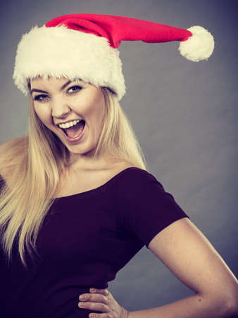 Xmas, seasonal clothing, winter christmas concept. Happy woman wearing Santa Claus helper hatの写真素材